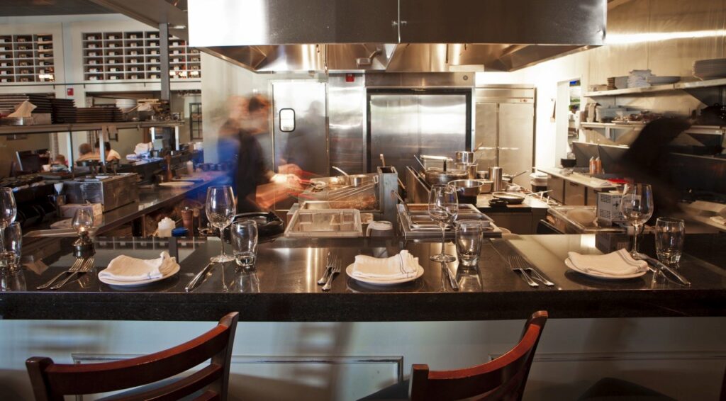 Busy kitchen scene with bar seating 